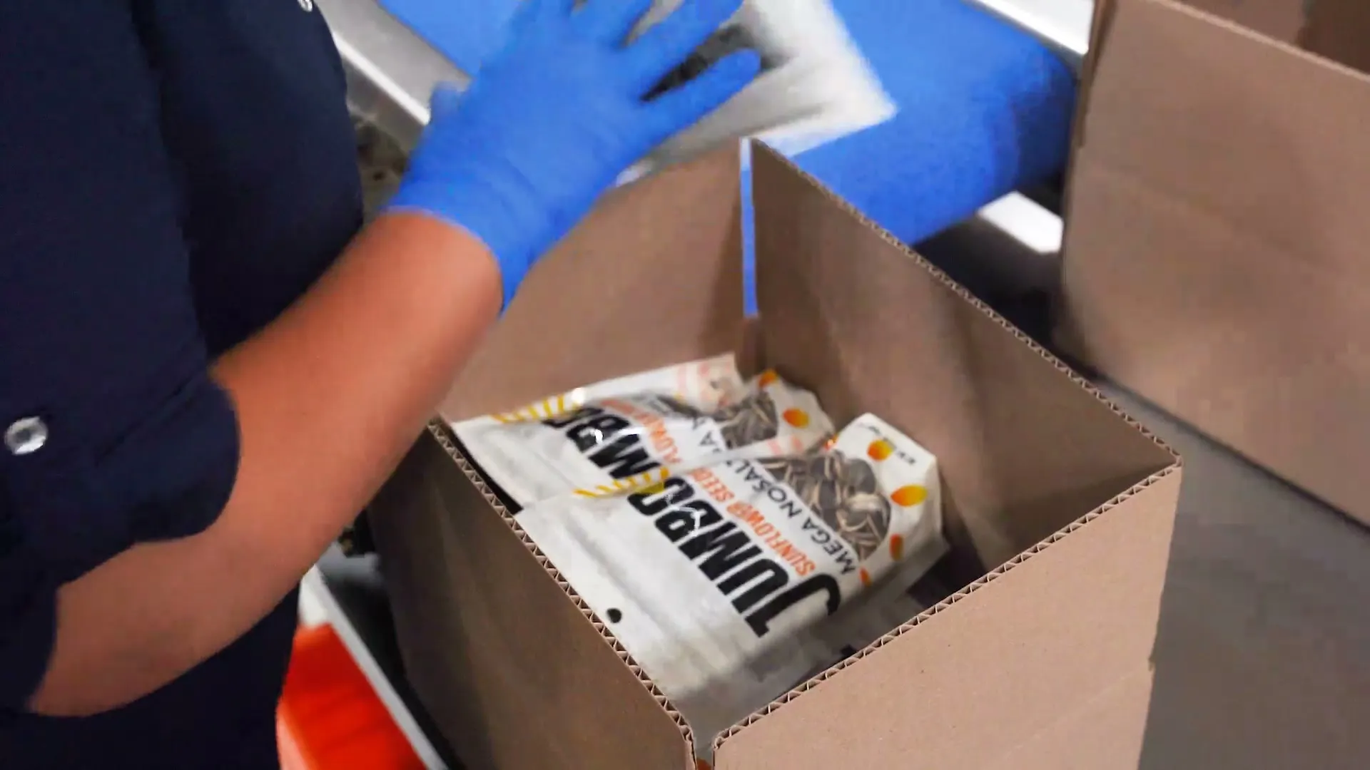 Gloved hands packing Jumbo bags into a case