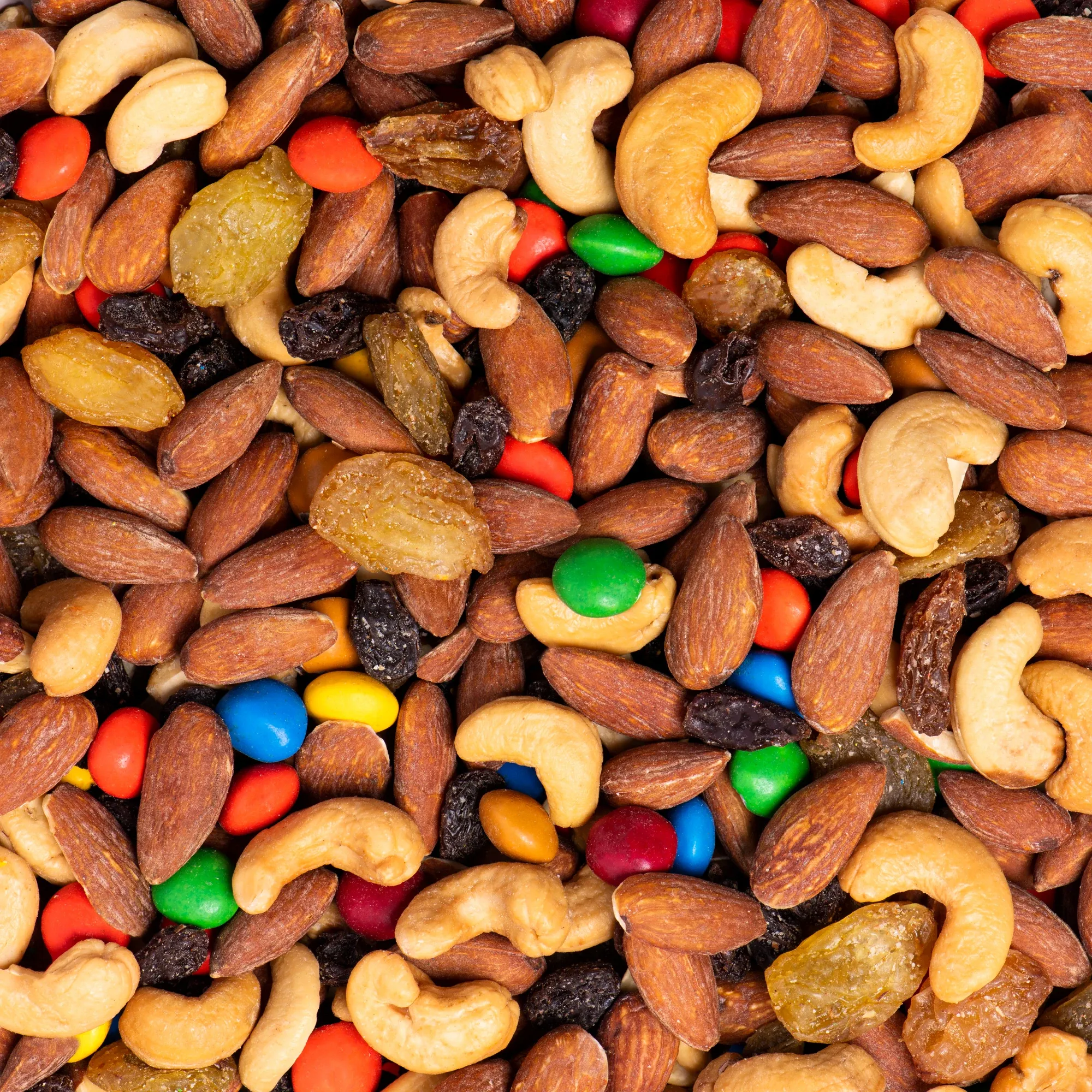 Trail mix of almonds, cashews, raisins and candy pieces, close up