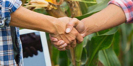 Performance Co-Packing Capabilities Customer Centric Approach Showing Hands Shaking in an Orchard Background